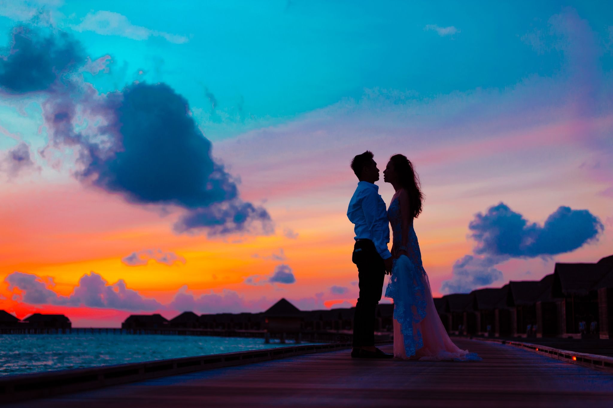 A couple at a private beachfront retreat at sunset